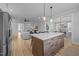 Open-concept kitchen featuring a large island, pendant lighting, and seamless flow into the living area at 140 Big Barn Dr, Wendell, NC 27591