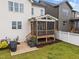 A lovely screened porch features wooden supports, a ceiling fan, and overlooks the grassy, fenced backyard at 140 Big Barn Dr, Wendell, NC 27591
