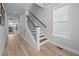 Elegant foyer staircase featuring hardwood floors, iron spindles, and natural light from nearby window at 140 Big Barn Dr, Wendell, NC 27591