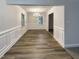 A dining room featuring new hardwood floors, updated wainscoting and a modern chandelier at 1508 Hodge Rd, Knightdale, NC 27545