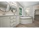 Bathroom with dual sinks, granite countertops, bathtub, and a walk-in closet at 160 Deer Tracks Dr, Wendell, NC 27591