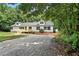 Charming single-story home featuring a front deck and a gravel driveway nestled among lush trees at 160 Deer Tracks Dr, Wendell, NC 27591