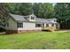 View of a home's exterior with dormer windows, a front deck, and lush green landscaping at 160 Deer Tracks Dr, Wendell, NC 27591