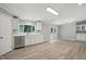 Bright, open kitchen featuring gray walls, stainless steel appliances, white cabinets, and wood-look flooring at 160 Deer Tracks Dr, Wendell, NC 27591