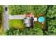 Aerial view of property featuring a backyard pool, house, outbuilding, gravel drive, and surrounding trees at 1605 Goldsboro Ave, Sanford, NC 27330