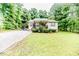 Charming home with a well-manicured lawn, complemented by a convenient carport and lush trees at 1605 Goldsboro Ave, Sanford, NC 27330