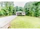 Charming single-story home featuring a well-manicured lawn, front porch, and gravel driveway at 1605 Goldsboro Ave, Sanford, NC 27330