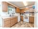 Charming kitchen featuring wood cabinets, white appliances, and vinyl flooring at 1605 Goldsboro Ave, Sanford, NC 27330