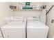 Functional laundry area featuring washer, dryer, overhead storage, and ironing board at 1605 Goldsboro Ave, Sanford, NC 27330