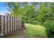A view of the backyard with a wooden fence and a grass lawn and landscaping at 1642 Holly Grove Way, Durham, NC 27713