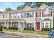Townhome with charming curb appeal, featuring colorful shutters and covered front porch entries at 1642 Holly Grove Way, Durham, NC 27713