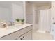 Bright bathroom featuring white cabinets, a white countertop, a white shower curtain and neutral-toned tiles at 1720 Pinecliff Ct, Fuquay Varina, NC 27526