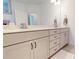 A bathroom with a bright white interior featuring a double vanity with neutral cabinets and quartz countertops at 1720 Pinecliff Ct, Fuquay Varina, NC 27526