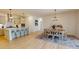 Spacious dining area adjacent to a modern kitchen featuring an island with seating and stainless steel appliances at 1720 Pinecliff Ct, Fuquay Varina, NC 27526