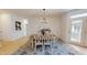 Light-filled dining room with a round table, six chairs, and stylish light fixture at 1720 Pinecliff Ct, Fuquay Varina, NC 27526