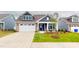 Well-manicured front lawn leading to a two-story home with a two-car garage and covered entryway at 1720 Pinecliff Ct, Fuquay Varina, NC 27526