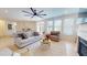 Bright living room featuring a ceiling fan, hardwood floors, and many windows at 1720 Pinecliff Ct, Fuquay Varina, NC 27526