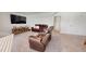 Spacious living room with plush carpeting, media center, and reclining leather seating for a relaxing ambiance at 1720 Pinecliff Ct, Fuquay Varina, NC 27526