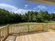Wide backyard view from a wooden deck overlooking lawn, trees, and cloudy skies at 176 Bonsai Way, Four Oaks, NC 27524