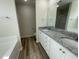 Modern bathroom with a double granite vanity, neutral wall paint, and wood-look tile floors at 176 Bonsai Way, Four Oaks, NC 27524