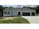 Charming single-story home with sage green siding, black garage doors, and manicured lawn at 176 Bonsai Way, Four Oaks, NC 27524