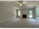 Bright living room featuring a fireplace, neutral walls, ceiling fan, and large windows at 176 Bonsai Way, Four Oaks, NC 27524