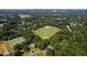 Aerial view of property surrounded by lush greenery, near baseball field and Raleigh skyline at 1825 Watkins St, Raleigh, NC 27604