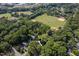 Aerial view of property surrounded by lush greenery, near baseball field, tennis court and Raleigh skyline at 1825 Watkins St, Raleigh, NC 27604