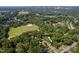 Aerial view of property surrounded by lush greenery, near baseball field and Raleigh skyline at 1825 Watkins St, Raleigh, NC 27604