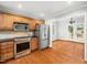 Well-equipped kitchen with stainless steel appliances, wood cabinets, and an open view to a dining area at 1825 Watkins St, Raleigh, NC 27604