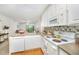 White kitchen featuring modern appliances and stone countertops, open to the living area at 1851 Trailwood Heights Ln # 204, Raleigh, NC 27603