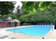 Beautiful community pool with lounge chairs and a pool house, surrounded by lush greenery at 1851 Trailwood Heights Ln # 204, Raleigh, NC 27603
