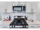 Close-up of a sleek gas cooktop and stainless steel microwave in a modern kitchen at 2019 Nebula Way, Durham, NC 27703