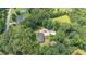 Aerial view of the home nestled among mature trees, driveway, and separate garage at 2139 Race Track Rd, Burlington, NC 27215