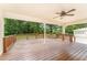 Large back deck with a ceiling fan and railing overlooks the spacious wooded backyard at 2139 Race Track Rd, Burlington, NC 27215