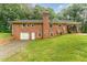 Back exterior view of brick home with garage, large yard, and covered deck at 2139 Race Track Rd, Burlington, NC 27215