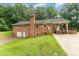 Back exterior view of brick home with garage, large yard, and covered deck at 2139 Race Track Rd, Burlington, NC 27215