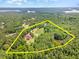This aerial shot of a lakeside property highlights its expansive lot, wooded privacy and surrounding lake views at 2540 Seaforth Rd, Pittsboro, NC 27312