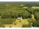 Wide aerial shot showcasing the property with lush greenery, surrounding trees, and a detached garage at 2819 Russell Mcpherson Rd, Burlington, NC 27215