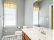 Cozy bathroom featuring a large vanity mirror, toilet, and window at 2819 Russell Mcpherson Rd, Burlington, NC 27215