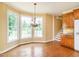 Open dining area features hardwood floors, a decorative chandelier, and natural light at 2819 Russell Mcpherson Rd, Burlington, NC 27215