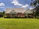 Back exterior view of brick home with mature landscaping and a brick facade at 2819 Russell Mcpherson Rd, Burlington, NC 27215