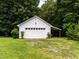 Front view of a two-car detached white garage with yard and trees at 2819 Russell Mcpherson Rd, Burlington, NC 27215