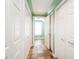 Hallway with hardwood floors and white closet doors at 2819 Russell Mcpherson Rd, Burlington, NC 27215