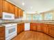 Kitchen featuring custom cabinets, granite countertops, white appliances, tile backsplash, and hardwood floors at 2819 Russell Mcpherson Rd, Burlington, NC 27215