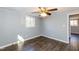 A bright bedroom with wood-look flooring, a ceiling fan, and a window for natural light at 3013 Avery St, Raleigh, NC 27610