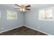 Bedroom featuring wood-look flooring, two windows, and neutral paint at 3013 Avery St, Raleigh, NC 27610
