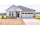Charming home with stone accents, neutral siding, well-manicured yard, and a two-car garage at 324 Longleaf Glen Court, Zebulon, NC 27597
