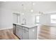 Open kitchen with gray island with sink, stainless steel appliances, and modern lighting at 324 Longleaf Glen Court, Zebulon, NC 27597