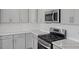 Modern kitchen with sleek gray cabinets, stainless steel appliances, and stylish backsplash at 324 Longleaf Glen Court, Zebulon, NC 27597